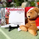 Mistletoe's Night book and teddy bear on a table at a faire